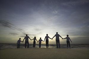 Familia tomada de la mano en la playa